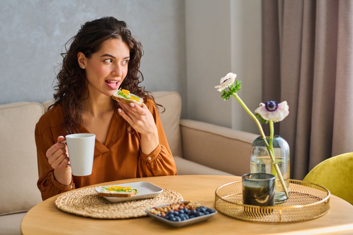 5 Fresh Snack Ideas Woman enjoying healthy meal at home table with flowers and water glass